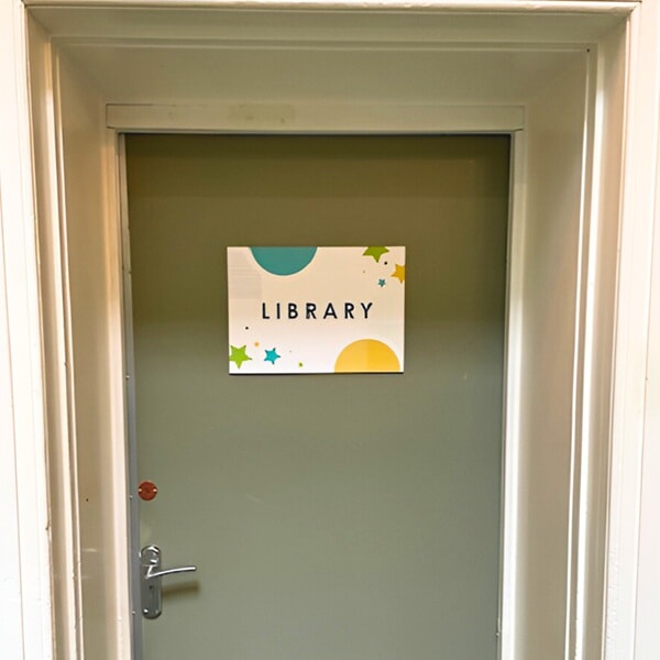 An image of the library sign on a door.